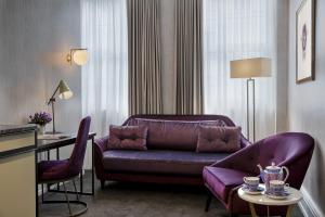 オークランドにあるFable Auckland, MGalleryの紫色のソファとテーブル付きのリビングルーム