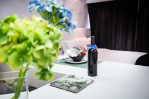 a white table with flowers and a bottle on it at V Wanchai in Hong Kong