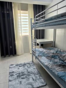 - une chambre avec 2 lits superposés et un bureau dans l'établissement Casa Moanna 2BR-3beds spacious Dining, kitchen,Living Area, Wifi, à Mandaue City
