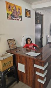une femme assise sur une chaise au bureau dans l'établissement Hari Kripa Sadan, à Ayodhya