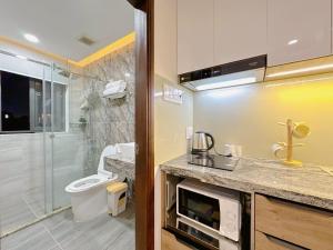 y baño con ducha, aseo y lavamanos. en Riverside house Quận Phú Nhuận, en Ho Chi Minh