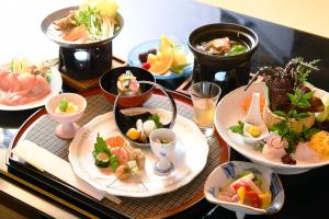 einen Tisch mit Teller mit Lebensmitteln auf einem Tisch in der Unterkunft Seizan Yamato in Ito
