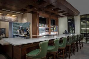 a bar with green chairs at a restaurant at Courtyard by Marriott Thomasville Downtown in Thomasville