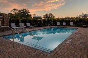 a large swimming pool with chairs and a table at Courtyard by Marriott Thomasville Downtown in Thomasville