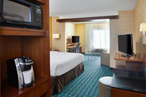 a hotel room with a bed and a flat screen tv at Fairfield Inn & Suites by Marriott Atlanta Lithia Springs in Lithia Springs