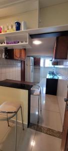 a kitchen with a counter and two chairs in it at Apartamento Conforto/Praticidade in Manaus +6 photos