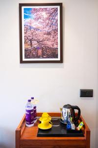 un tavolo con bollitore per tè e una foto appesa al muro di ANGKASA LADAKH RESORT a Leh