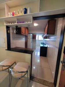 a small kitchen with two stools and a counter top at Apartamento Conforto/Praticidade in Manaus