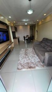 a living room with a couch and a flat screen tv at Apartamento Conforto/Praticidade in Manaus