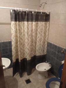 a bathroom with a shower curtain and a toilet at Departamento West in Las Heras