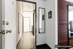 a hallway with a mirror on the wall and a door at Habitaciones Smith in San José