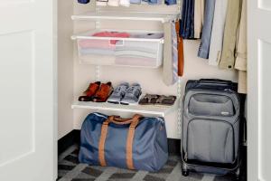 a walk in closet with luggage and clothes at TownePlace Suites by Marriott Houston Baytown in Baytown