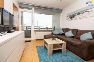 a living room with a couch and a coffee table at Ferienhaus Seeblick - Wohnung 85 in Borkum