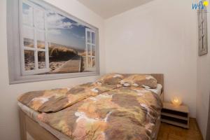 a bedroom with a bed and a window at Ferienhaus Seeblick - Wohnung 85 in Borkum