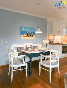 uma cozinha e sala de jantar com mesa e cadeiras em Luv und Lee - Ferienwohnung Juister Stuv em Juist