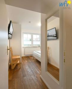 Zimmer mit einem Schlafzimmer mit einem Spiegel und einem Bett in der Unterkunft Luv und Lee - Ferienwohnung Juister Stuv in Juist