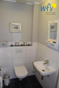 a bathroom with a white toilet and a sink at Haus Kiek in't Watt Ferienwohnung Deichrausch in Juist