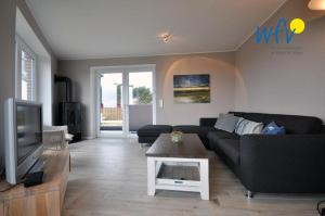 a living room with a couch and a tv at Haus Kiek in't Watt Ferienwohnung Deichrausch in Juist