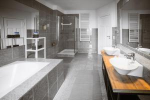 a bathroom with two sinks and a tub and a shower at Kaminstube im Goethequartier in Bremerhaven