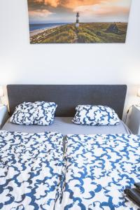 a bed with two pillows and a picture of a cross at Kaminstube im Goethequartier in Bremerhaven