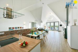 a kitchen and a living room with a table with a bowl of fruit at Haus Kiek in't Watt- Ferienwohnung Quartier 7 Ost in Juist