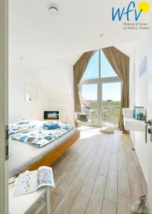 a bedroom with a bed and a large window at Haus Kiek in't Watt- Ferienwohnung Quartier 7 Ost in Juist