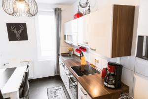 a kitchen with white cabinets and a wooden counter top at Kaminstube im Goethequartier in Bremerhaven