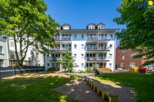 an apartment building with a park in front of it at Appartement-Haus Regina Ferienwohnung Sonnendeck in Borkum