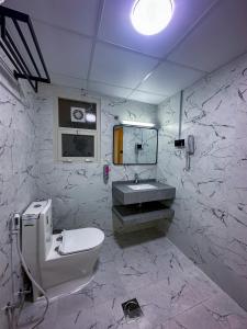 杜拜的住宿－GOLD SKY AVENUE HOTEL，白色的浴室设有水槽和卫生间。