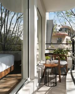 墨西哥城的住宿－Kimpton Virgilio，露台的阳台配有桌椅