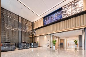 a lobby with a large screen in a building at Mehood Elegant Hotel Guangzhou Baiyun Airport Huadu Cultural Tourism City in Huadong