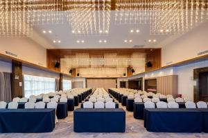 una sala de conferencias con filas de sillas y lámparas de araña en Mehood Elegant Hotel Guangzhou Baiyun Airport Huadu Cultural Tourism City en Huadong