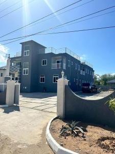 a blue building with a car parked in front of it at CLIFF POINT in Treasure Beach