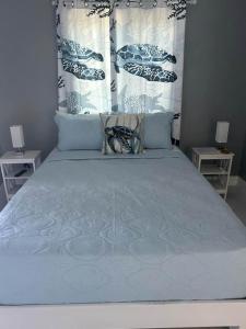 een slaapkamer met een groot bed en een blauw dekbed bij CLIFF POINT in Treasure Beach