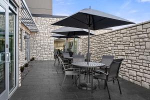 Fairfield by Marriott Inn & Suites Cape Girardeau في كاب جيراردو: طاولة وكراسي مع مظلة على الفناء