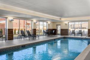 a swimming pool with chairs and a table in a building at Fairfield by Marriott Inn & Suites Cape Girardeau in Cape Girardeau