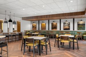 a restaurant with tables and chairs and a bar at Fairfield by Marriott Inn & Suites Cape Girardeau in Cape Girardeau