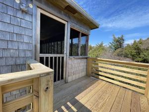 a wooden deck with a window on a house at SUNFISH COVE cottage in Avon