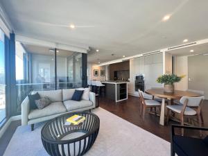 uma sala de estar com um sofá e uma mesa em Samma Flagstaff Luxury Apartments em Melbourne