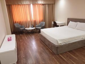 um quarto com uma cama, 2 cadeiras e uma mesa em Phù Đổng Hotel Thanh Hóa em Thanh Hóa