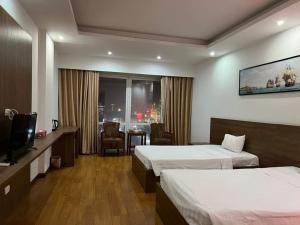 pokój hotelowy z 2 łóżkami i telewizorem w obiekcie Phù Đổng Hotel Thanh Hóa w mieście Thanh Hóa