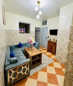Apartment with 2 bedrooms في الصويرة: غرفة معيشة مع أريكة زرقاء وطاولة