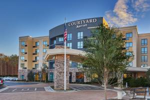 a hotel with a flag in front of a building at Courtyard by Marriott Atlanta Lithia Springs in Lithia Springs