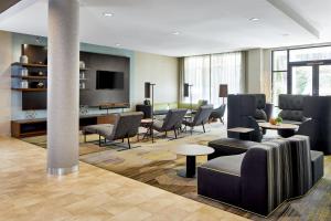 a lobby with a waiting room with chairs and tables at Courtyard by Marriott Atlanta Lithia Springs in Lithia Springs