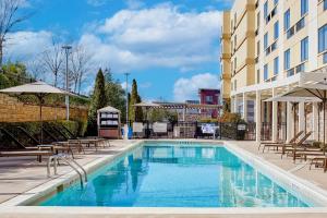 a pool at a hotel with chairs and umbrellas at Courtyard by Marriott Atlanta Lithia Springs in Lithia Springs