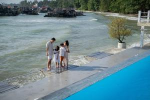a family standing on a dock by the water at Bintan Exotica Resort in Berakit