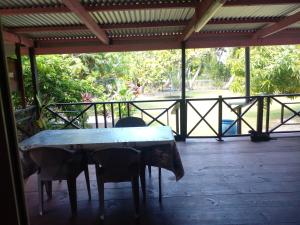 einen Tisch und Stühle auf einer Veranda mit Aussicht in der Unterkunft Sunset beach maupiti in Te-Fare-Arii