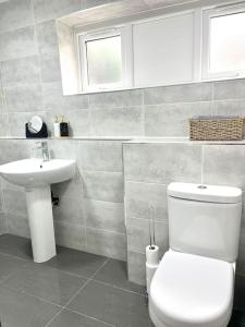 a bathroom with a white toilet and a sink at Modern Apartment In The Heart Of Kensington in Liverpool