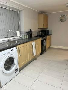 a kitchen with a washing machine and a sink at Modern Apartment In The Heart Of Kensington in Liverpool