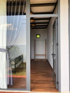an open door to a balcony with a view at Doi Hoa Do Homestay in Bao Loc